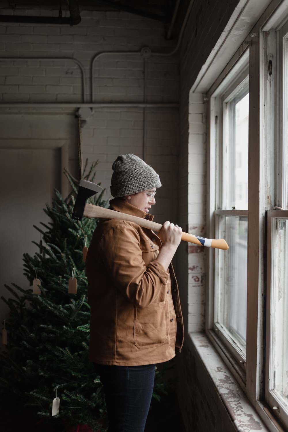 Person wearing Duckworth Woolfill Jacket indoors holding an axe by a window